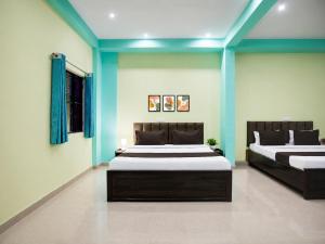 two beds in a room with blue walls at Rudraksh Residency in Varanasi