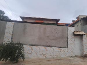 a stone wall with a gate and a building at casa em Vila Verde Búzios in Búzios