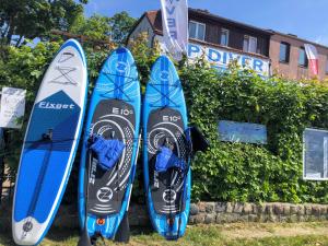 three surfboards are lined up next to each other at Dom Gaja in Ińsko +13 photos