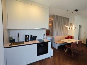 a kitchen with white cabinets and a table in a room at Studios zur Schmiede in Weyregg +11 photos