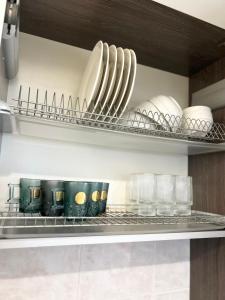 a shelf with plates and dishes on it in a kitchen at Квартира Иртыш in Pavlodar +1 photo