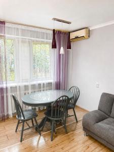 a living room with a table and chairs and a couch at Квартира Иртыш in Pavlodar