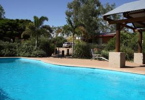 a large swimming pool in a tropical setting at Rubyvale Motel & Holiday Units in Rubyvale