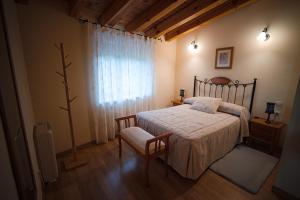 a bedroom with a bed and a chair and a window at Casa Rural La Celestina in Navalmoro