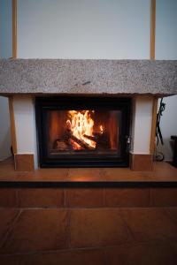 a fireplace with fire in the middle of a room at Casa Rural La Celestina in Navalmoro