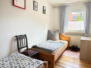 a bedroom with a bed and a chair and a window at Ferienwohnung im Ort in Röbel