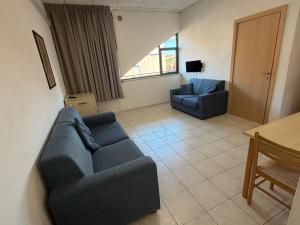 a living room with a blue couch and a table at Polena Residence Hotel in Marina di Montenero