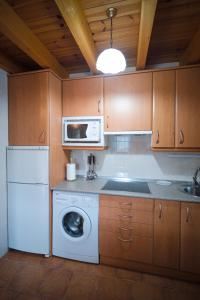a kitchen with a washing machine and a microwave at Casa Rural La Celestina in Navalmoro +14 photos