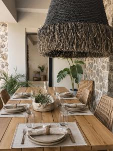 a dining room table with a large chandelier at Villa Tartaya Boutique Villa with Private Pool in Corfu in Dassia