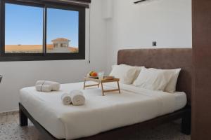 a bedroom with a large white bed with towels on it at The Retro Suite Kato Paphos 2 min to the beach in Paphos