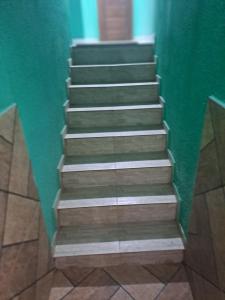 a set of stairs in a room with a green wall at casa em Vila Verde Búzios in Búzios +1 photo