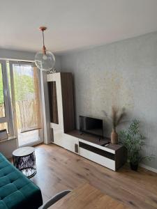 a living room with a couch and a tv at Apartament Leśna Mandala in Augustów