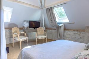 a bedroom with a bed and a desk with a television at Chambre duo in Sainte-Gemme-la-Plaine