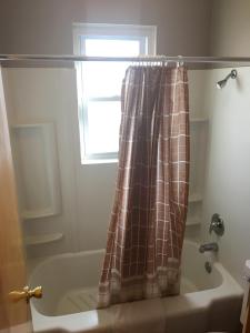 Un baño con bañera y cortina de ducha. en The King's Inn, en Sidney 23 fotos más