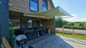 an outdoor kitchen with an umbrella on a deck at Zacisze Mrozy in Ełk