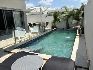 a swimming pool with chairs and a table on a patio at Geron's וילת אירוח in Bet Sheʼan