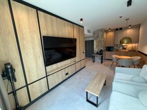 a living room with a large wall with a tv at Apartament - VIDOK 110 in Olsztyn