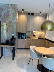 a kitchen with a table and some chairs and a counter at Apartament - VIDOK 110 in Olsztyn +2 photos