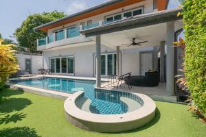 a swimming pool in front of a house at Luxury 4 Bedroom Beach House in Ban Saiyuan (1)
