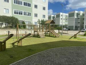 a park with a wooden playground in front of a building at Apartamento Flores do Bosque in Garanhuns