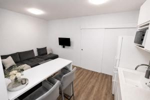 a living room with a couch and a table at ALURE RESIDENCES 1 & 24h self check-in, free parking in front of the apartment building, new building, terrace, cafe with breakfast in the apartment building, next to the aqua park in Banská Bystrica
