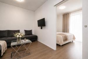 a living room with a couch and a bed at ALURE RESIDENCES 1 & 24h self check-in, free parking in front of the apartment building, new building, terrace, cafe with breakfast in the apartment building, next to the aqua park in Banská Bystrica
