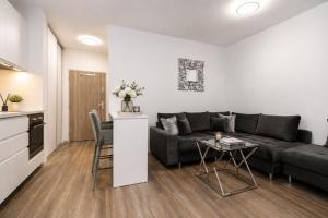 a living room with a couch and a table at ALURE RESIDENCES 1 & 24h self check-in, free parking in front of the apartment building, new building, terrace, cafe with breakfast in the apartment building, next to the aqua park in Banská Bystrica +7 photos