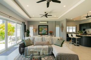 a living room with a couch and a ceiling fan at Luxury 4 Bedroom Beach House in Ban Saiyuan (1)