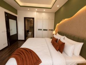 a bedroom with a bed with white sheets and pillows at Designer One Bedroom Apartment With Balcony & Mountain Views Opposite Centaurus Mall ISB in Islamabad