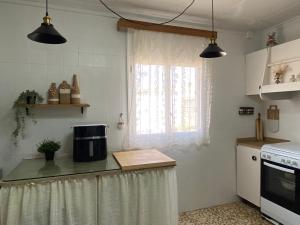 a kitchen with a window and a counter with a microwave at Casa Perico Reyes in Cartagena