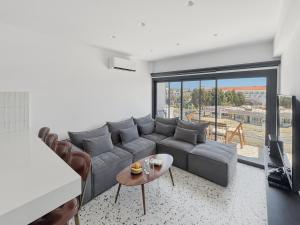 a living room with a gray couch and a table at The Retro Suite Kato Paphos 2 min to the beach in Paphos
