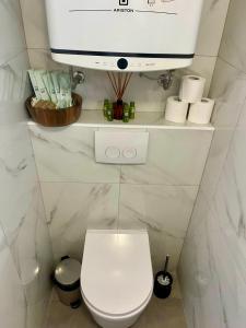 a bathroom with a toilet and a tv on a wall at Blue Coast Ivo in Piran +10 photos