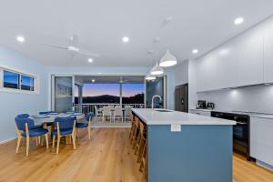 a kitchen and dining room with a table and chairs at Seabreeze Lookout Azul in Airlie Beach
