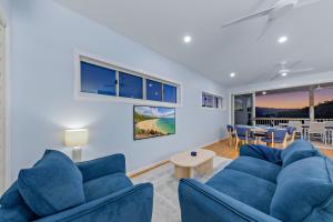 a living room with blue couches and a table at Seabreeze Lookout Azul in Airlie Beach