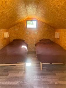 two beds in a room with a window at Camping de la Pelouse in Jaulny +21 photos