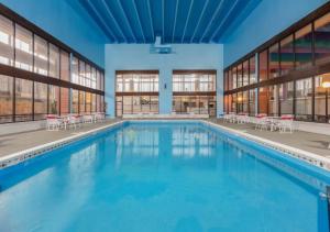a large swimming pool in a building with tables and chairs at Boutique Hotel in Texarkana