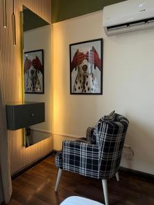 a living room with a chair and a mirror at Designer One Bedroom Apartment With Balcony & Mountain Views Opposite Centaurus Mall ISB in Islamabad