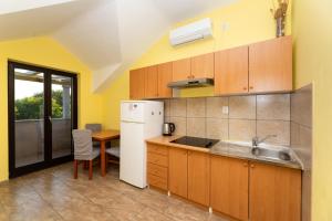 a kitchen with a white refrigerator and a table at Vikendica Donji Humac in Donji Humac