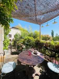 a patio with a table and chairs with a hat on it at Le Jardin De Gustave in Ornans