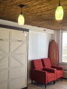 a room with a red chair and a sliding door at The Surf Shack at Harbour Beach Resort in Daytona Beach