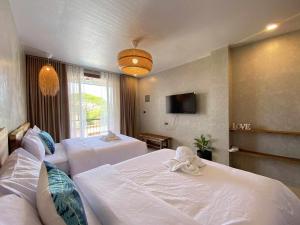 ein Hotelzimmer mit zwei Betten und einem Fernseher in der Unterkunft Balay Isabel in San Juan + 5 Fotos