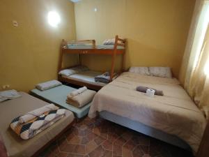 a room with two beds and a bunk bed at Mi Hábitat Lambaré - Habitaciones con Baño Privado, Cocina y Comedor equipados con electrodomésticos, con Quincho al Aire Libre in Asunción