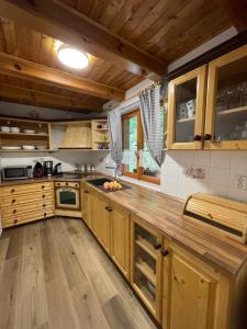 a kitchen with wooden cabinets and a wooden floor at Chata Harmony in Ružomberok