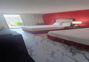 two beds in a hotel room with red walls at Boutique Hotel in Texarkana