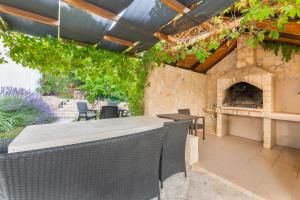 an outdoor patio with a table and a fireplace at Vikendica Donji Humac in Donji Humac