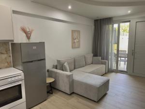 a living room with a couch and a kitchen at Otium Studios in Limenaria