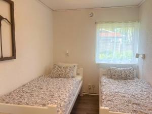 a bedroom with two beds and a window at Schwedenhaus am See in Storfors