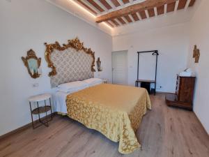 a bedroom with a bed and a table and a mirror at Albergo Il Marzocco - Hotel dal 1860 in Montepulciano