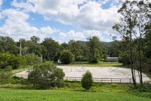 a large field with a fence and trees at Spacious 6BR Mansion with Pool Sauna BBQ in Gold Coast