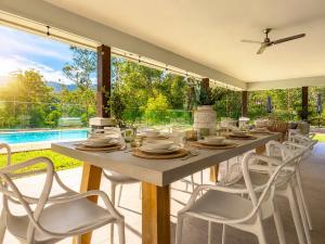 a dining room with a table and white chairs at Spacious 6BR Mansion with Pool Sauna BBQ in Gold Coast